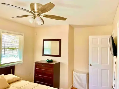 a bedroom with a ceiling fan and a bed and a dresser at Scenic Views & River Access, Cozy River Home in Montague