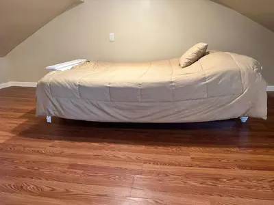 a bed in a bedroom with a wooden floor at Forest and River Side Tranquil House in Montague