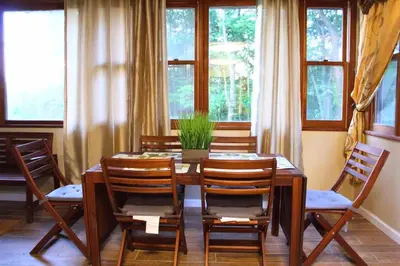 a dining room with a table and chairs and windows at Rare River Views & Access, Cabin by Eden Islands in Montague