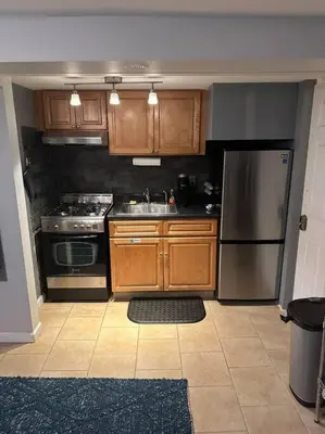 a kitchen with wooden cabinets and a stainless steel refrigerator at Morris Park area(very close to Jacobi Hospital in Morris Park