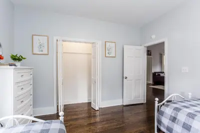 a white bedroom with a bed and a dresser at 2 Bedroom Apartment Near Bristol Center in Bristol