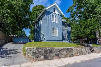 a blue house with a stone wall in front of it at 2 Bedroom Apartment Near Bristol Center in Bristol