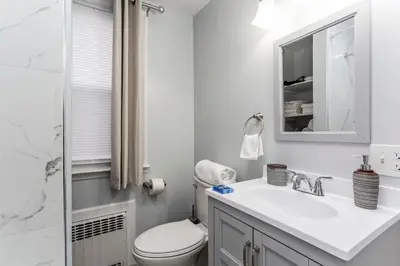 a bathroom with a sink and a toilet and a mirror at 2 Bedroom Apartment Near Bristol Center in Bristol