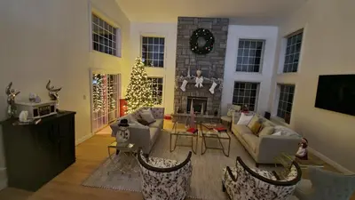 a living room with a christmas tree and a fireplace at Hilltop Mansion at Rebecca's Fountain in Niskayuna