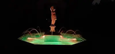 a fountain with a statue on top of it at night at Hilltop Mansion at Rebecca's Fountain in Niskayuna