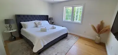 a bedroom with a bed with white sheets and a window at Hilltop Mansion at Rebecca's Fountain in Niskayuna