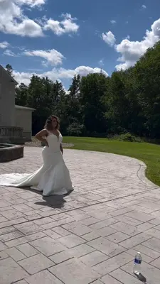a woman in a wedding dress standing on a patio at Hilltop Mansion at Rebecca's Fountain in Niskayuna