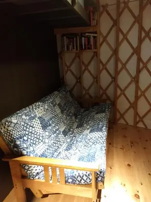 a bed in a room with a book shelf at Livingston Manor YURT in Parksville