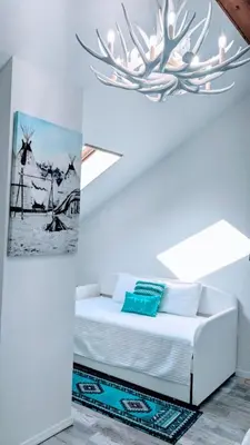 a bedroom with a white bed and a chandelier at Great Gorge-ous condo in Vernon Township