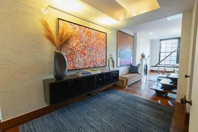 a living room with a large painting on the wall at E10-3 3BR Designer Townhouse in New York