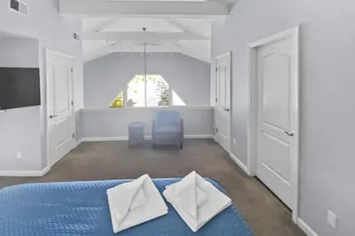 a bedroom with a blue bed with white pillows on it at Cottage at Sunny Day in Newtown