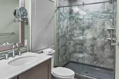 a bathroom with a shower and a toilet and a sink at Cottage at Sunny Day in Newtown