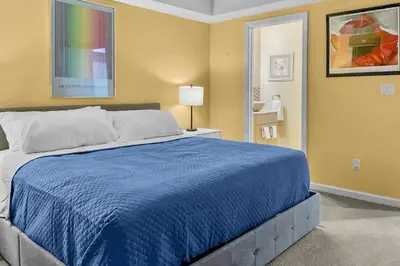 a bedroom with a large bed with a blue blanket at Cottage at Sunny Day in Newtown