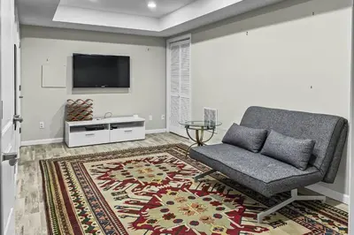 a living room with a chair and a flat screen tv at Cottage at Sunny Day in Newtown