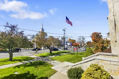 an american flag flying over a street with a church at Cottage at Sunny Day in Newtown