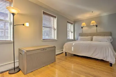 a bedroom with a white bed and two windows at Hoboken Condo Walk to Public Transit! in Hoboken