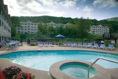 a large swimming pool with chairs and tables at Gorgeous 1st FL Mtn View Jiminy Suite Sleeps 4 Ski On Off in Hancock
