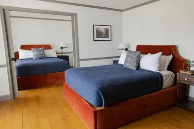 a bedroom with two beds and a mirror at Wylder Windham in Windham