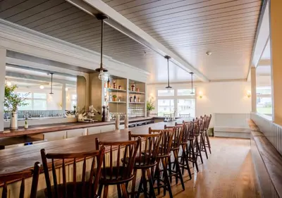 a dining room with a long table and chairs at Wylder Windham in Windham