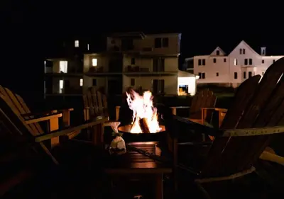 a fire pit in the middle of chairs at night at Wylder Windham in Windham