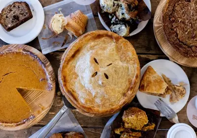 a table topped with pies and other desserts on plates at Wylder Windham in Windham