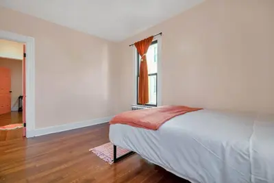 a white bedroom with a bed and a window at Peachy Paradise in East Rock Near DT/Yale in New Haven