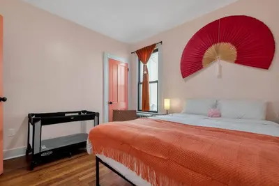 a bedroom with a bed with a red fan on the wall at Peachy Paradise in East Rock Near DT/Yale in New Haven