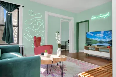 a living room with a couch and a tv at Green N' Groovy in the Heart of East Rock Near DT, Yale in New Haven