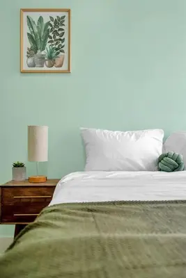 a bedroom with a bed and a table with a lamp at Green N' Groovy in the Heart of East Rock Near DT, Yale in New Haven