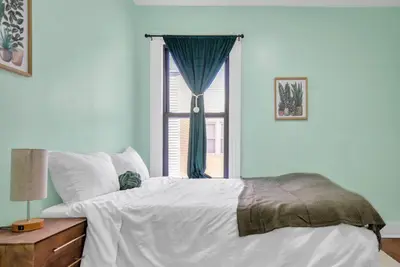 a bedroom with a large bed and a window at Green N' Groovy in the Heart of East Rock Near DT, Yale in New Haven