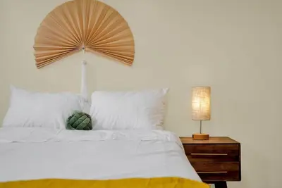a bedroom with a white bed with a lamp on a night stand at Golden Gem in Heart of East Rock Quiet 3BR Near DT and Yale in New Haven
