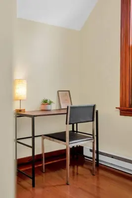 a desk with a chair and a table with a lamp at Golden Gem in Heart of East Rock Quiet 3BR Near DT and Yale in New Haven