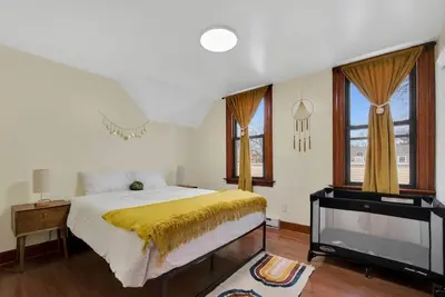 a bedroom with a large bed and a television at Golden Gem in Heart of East Rock Quiet 3BR Near DT and Yale in New Haven