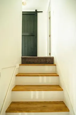 a staircase with a green door in a house at Cozy Cottage, Hot Tub, Fire Pit, 15min to Hudson and hiking in Catskill
