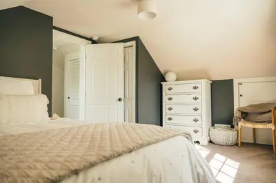 a bedroom with a large bed and a dresser at Cozy Cottage, Hot Tub, Fire Pit, 15min to Hudson and hiking in Catskill