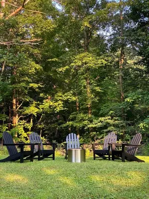 three park benches with a trash can in the grass at Cozy Cottage, Hot Tub, Fire Pit, 15min to Hudson and hiking in Catskill
