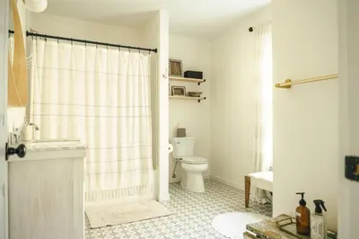 a white bathroom with a toilet and a shower at Cozy Cottage, Hot Tub, Fire Pit, 15min to Hudson and hiking in Catskill