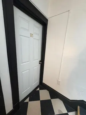 a room with a white door and a checkered floor at The Jazz Suite B1 in Hartford