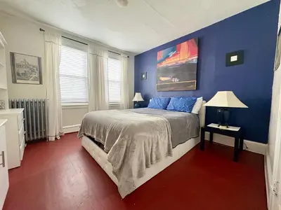 a bedroom with blue walls and a bed with blue pillows at The Jazz Suite B1 in Hartford