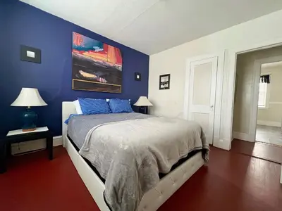 a bedroom with blue walls and a bed with blue pillows at The Jazz Suite B1 in Hartford