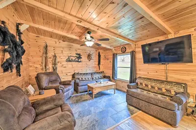 a living room with couches and a flat screen tv at Otego Home with Hot Tub Near All Star Village! in Oneonta