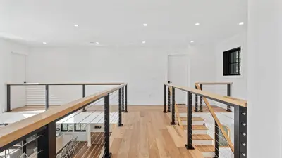 a staircase in a home with white walls and wood floors at Forget-Me-Not by AvantStay Bold Lakefront Escape in Monterey