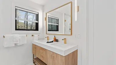 a bathroom with a white sink and a mirror at Forget-Me-Not by AvantStay Bold Lakefront Escape in Monterey