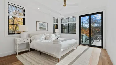 a white bedroom with a bed and windows at Forget-Me-Not by AvantStay Bold Lakefront Escape in Monterey