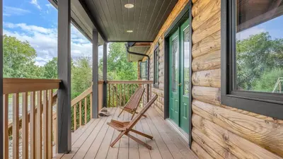 a porch with a rocking chair on a log cabin at Chester by AvantStay Amazing Views Secluded Home A True City Escape in Austerlitz