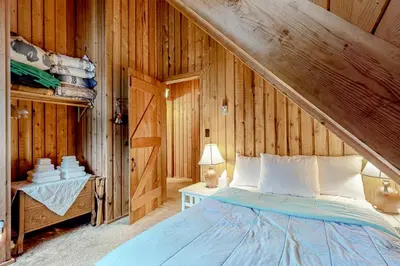 a bedroom with a bed and a wooden wall at Mowing Way Retreat in Wilmington
