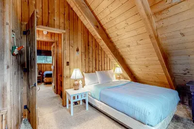 a bedroom with a bed in a log cabin at Mowing Way Retreat in Wilmington