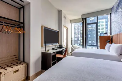 a hotel room with two beds and a flat screen tv at Tempo By Hilton New York Times Square in New York
