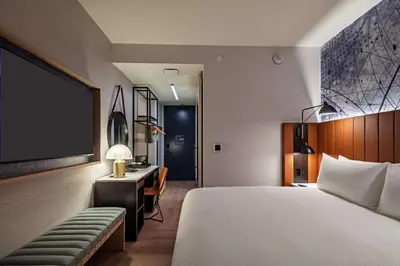 a bedroom with a bed and a desk and a tv at Tempo By Hilton New York Times Square in New York