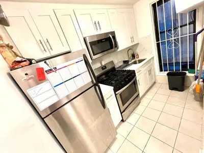 a kitchen with a stainless steel refrigerator and a microwave at Bedroom 10 mins to Times Square! and is first floor in Queens
